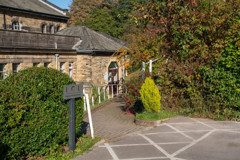 Building and car park with trees and directional sign