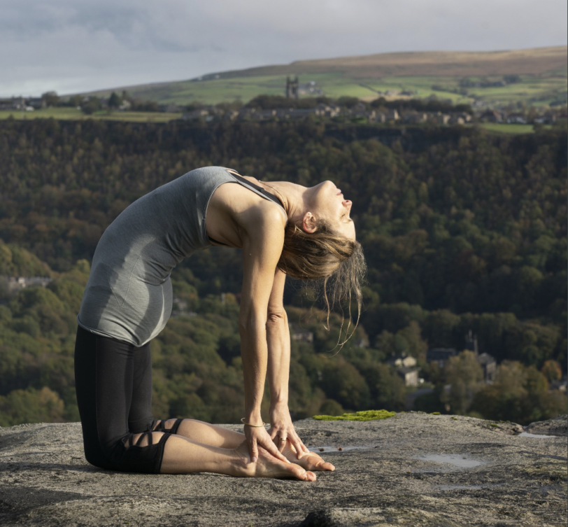 woman in yoga pose outside on rocks