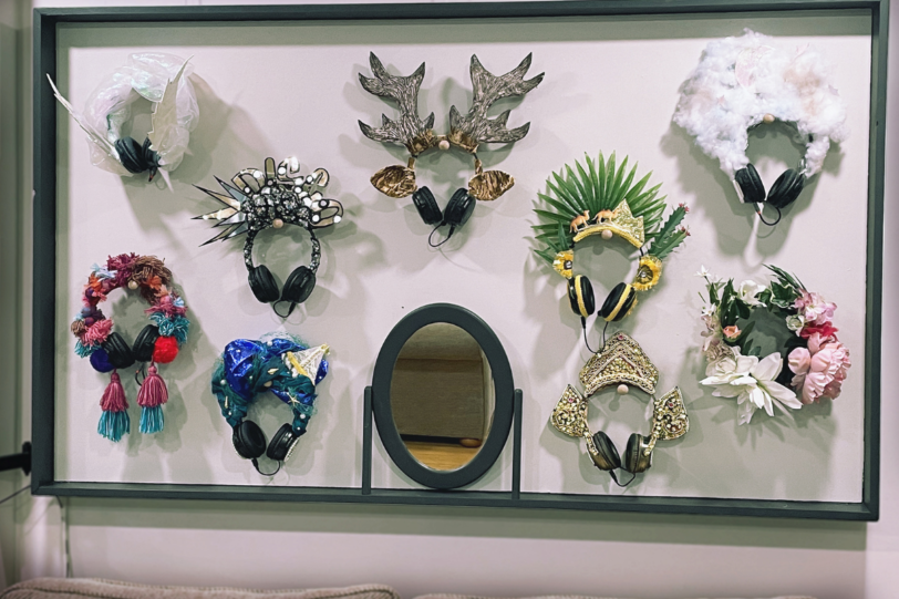 A wall display of decorative headresses and a mirror